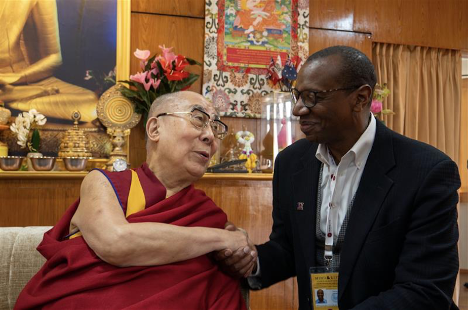 caption: Ed Taylor, vice provost and dean of Undergraduate Academic Affairs at the University of Washington, shakes the Dalai Lama's hands.