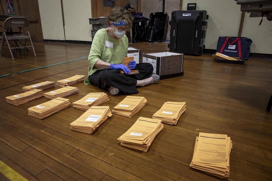 caption: Polling inspector Ann McClenahan counts early voting ballot envelopes at the polling station on Linnaean St. in Cambridge, Mass. (Robin Lubbock/WBUR)