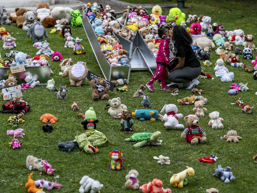 caption: A young girl and her mother visit a temporary art installation, called Bear the Truth, on June 28, 2020, at the Los Angeles City Hall. The installation honors Black children who have lost their lives to racial injustice and senseless violence.