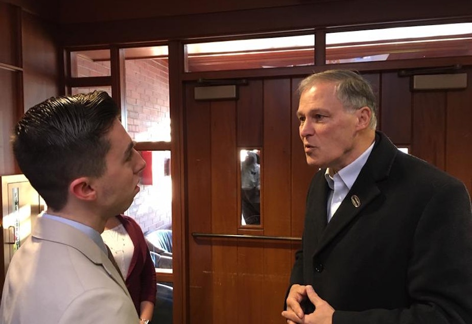 caption: Washington Gov. Jay Inslee speaks with a student at Saint Anselm College in Manchester, New Hampshire in January.