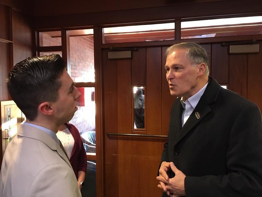 caption: Washington Gov. Jay Inslee speaks with a student at Saint Anselm College in Manchester, New Hampshire in January.