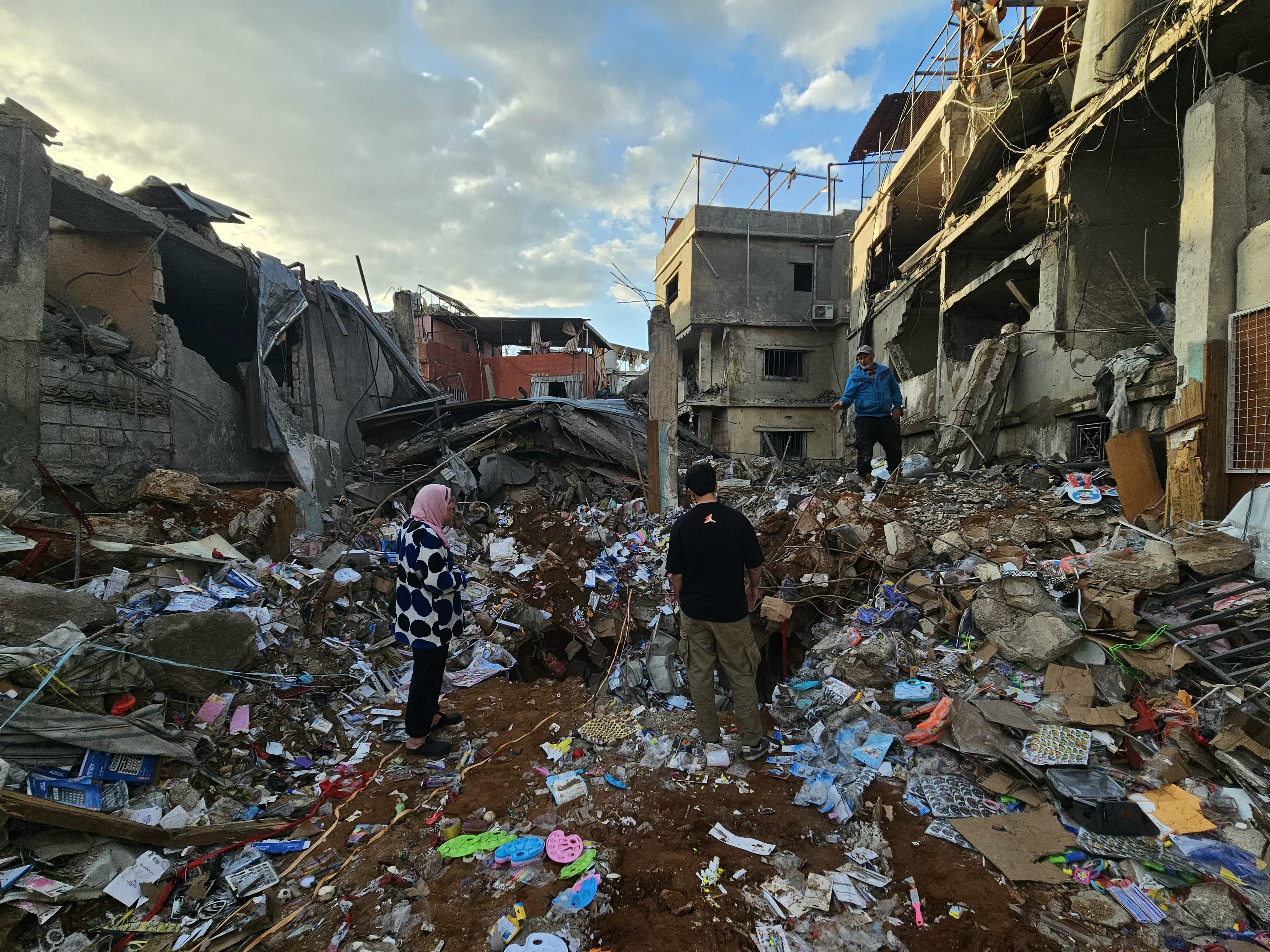 caption: People inspect the aftermath of Wednesday's Israeli airstrikes that targeted southern Beirut's al-Rihab neighborhood, April 9.