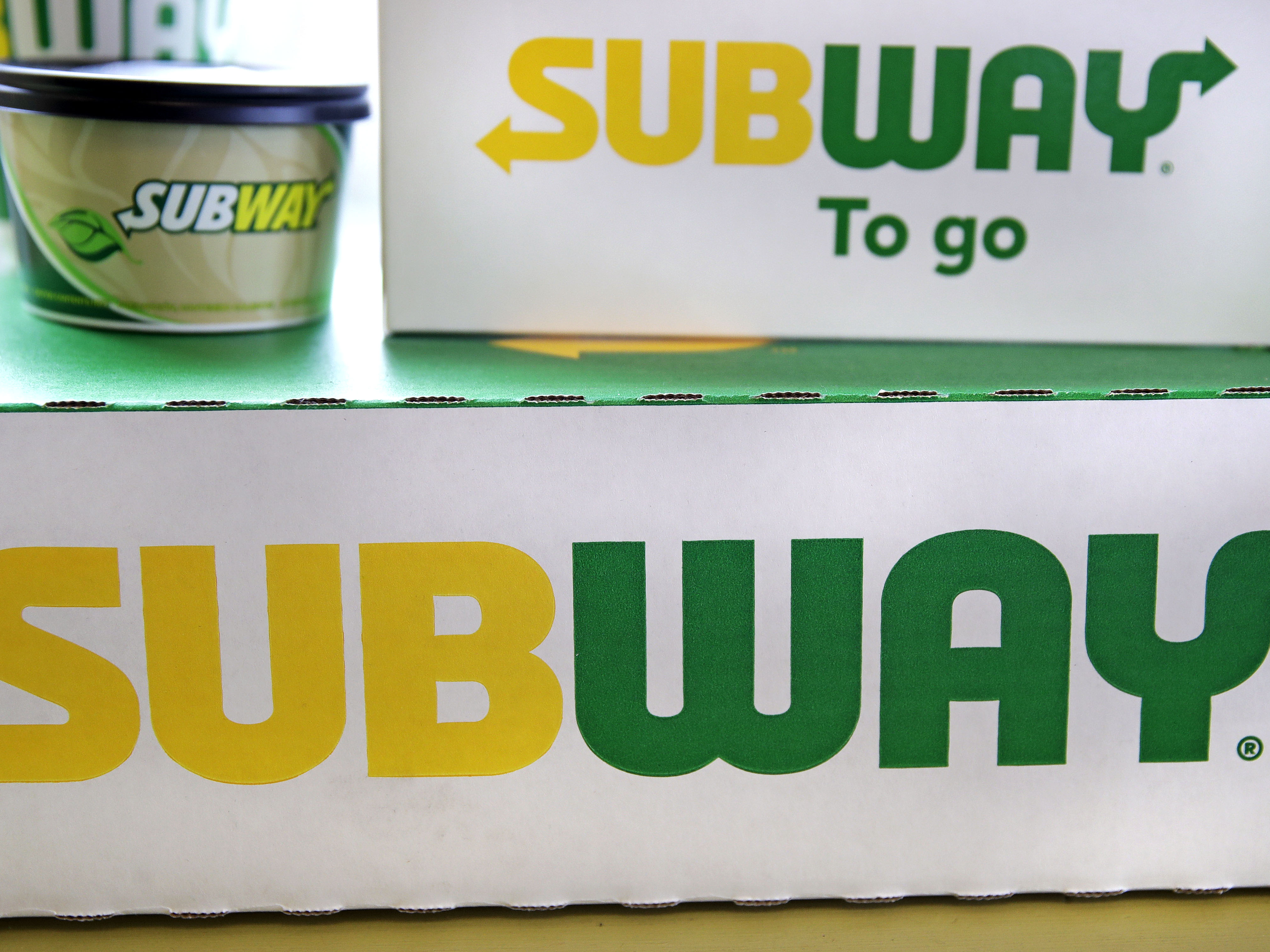caption: The Subway logo is seen on takeout boxes at a restaurant in Londonderry, N.H. The sandwich chain says it will be sold to the private equity firm Roark Capital. Terms of the deal weren't disclosed.