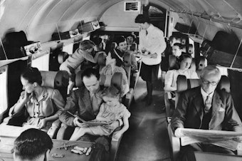 caption: Airplane passengers fly on a British plane in 1960. Travelers can often exhibit bizarre behaviors as a result of the conditions within the airplane cabin.