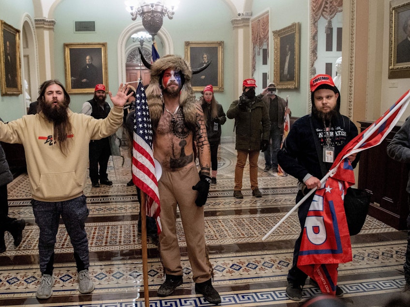 caption: Supporters of President Trump, including Jake Angeli (center), a QAnon supporter known for his painted face and horned hat, stand inside the U.S. Capitol on Jan. 6. Demonstrators breached security and entered the Capitol as Congress was in the process of tallying the 2020 electoral vote count.