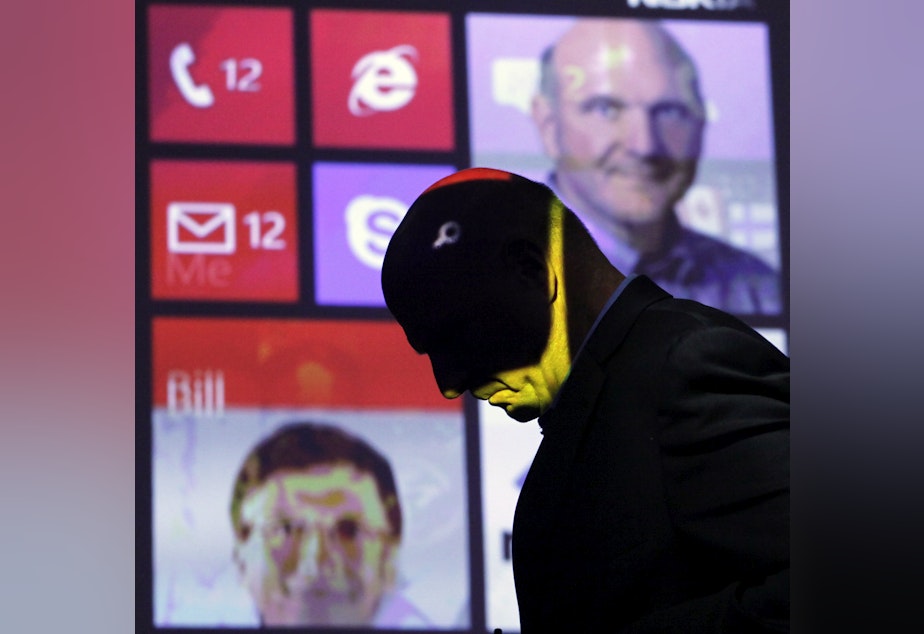 caption: Steve Ballmer, former CEO of Microsoft, walks past a projected display showing Bill Gates, lower left, and himself, during a discussion of Nokia's Lumia 920, equipped with Microsoft's Windows Phone 8, Sept. 5, 2012 in New York.