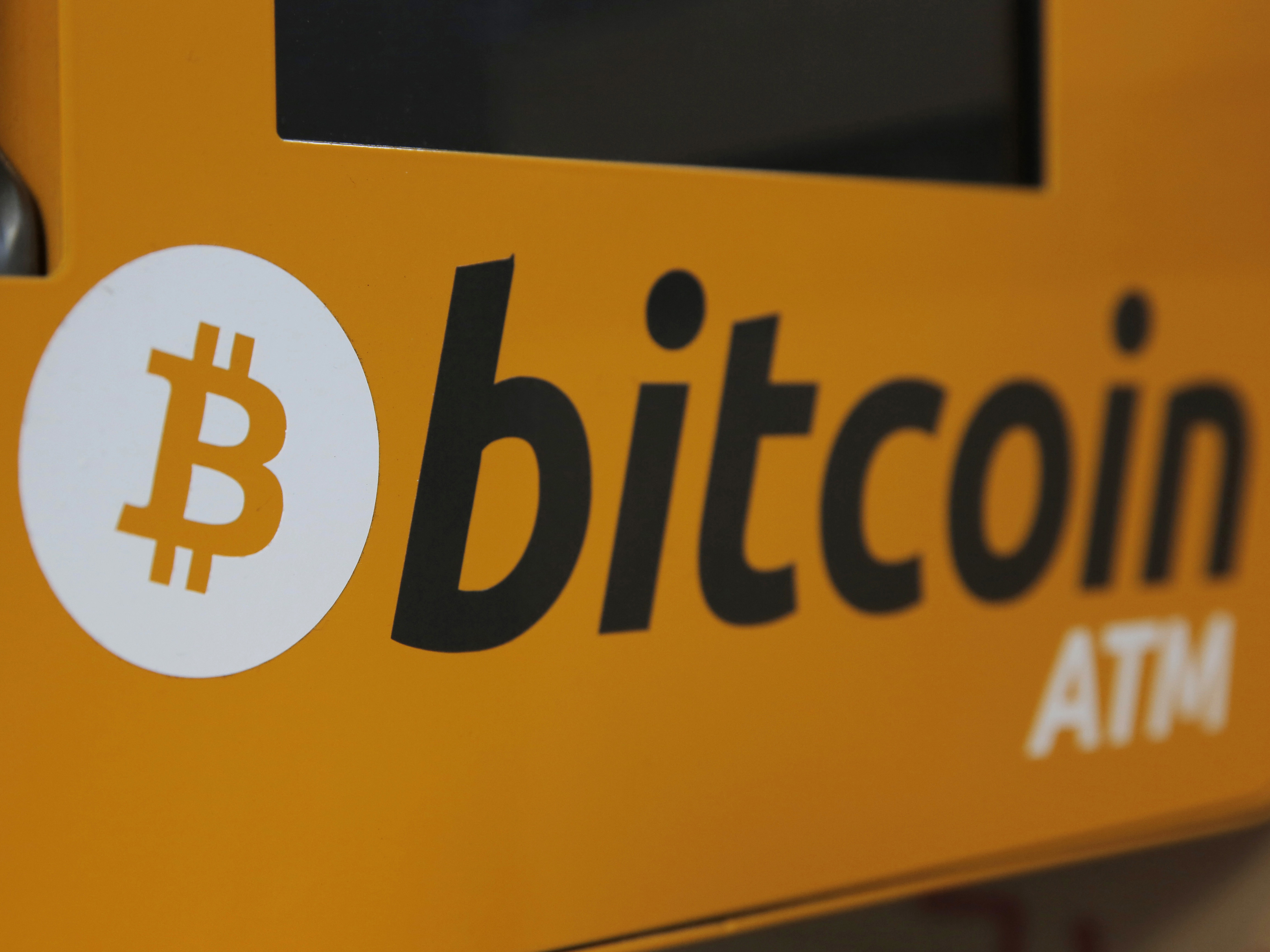 caption: A Bitcoin logo is displayed on an ATM in Hong Kong in 2017. More workers may soon be able to stake some of their 401(k) retirement savings to bitcoin.