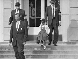 caption: U.S. Deputy Marshals escort 6-year-old Ruby Bridges from William Frantz Elementary School in New Orleans, in this November 1960, file photo. Lucille Bridges, Ruby's mother, died Tuesday at the age of 86.