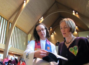 caption: Abby Brockway, right, a member of the Delta 5, sings with pastor Staci Imes at Woodland Park Presbyterian Church in Seattle. Brockway and four other activists face criminal charges for blocking BNSF Railway tracks in 2014.