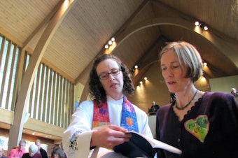 caption: Abby Brockway, right, a member of the Delta 5, sings with pastor Staci Imes at Woodland Park Presbyterian Church in Seattle. Brockway and four other activists face criminal charges for blocking BNSF Railway tracks in 2014.