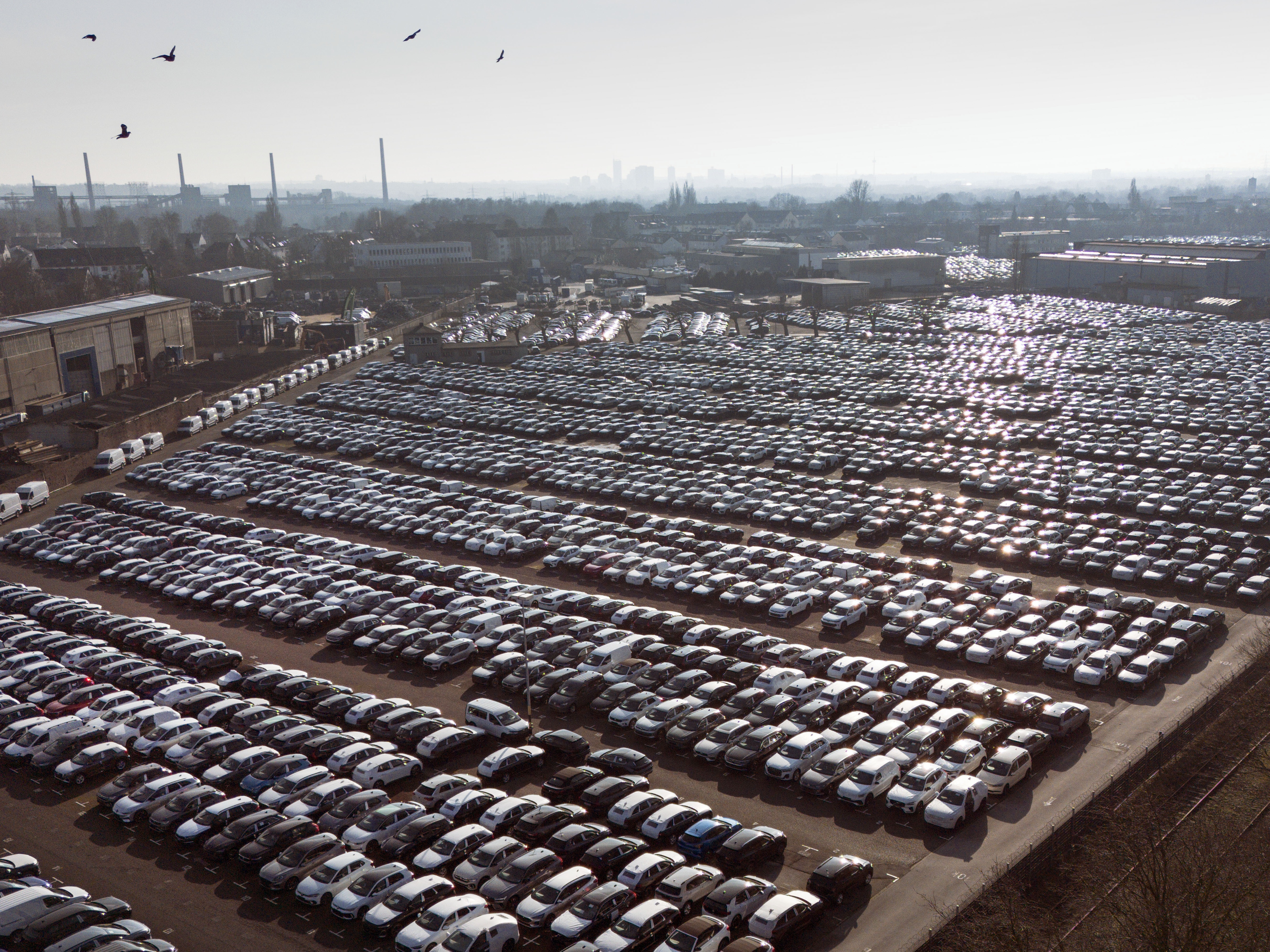 caption: New German cars are stored at a logistic center in Essen, Germany, Monday, Feb. 3, 2025.