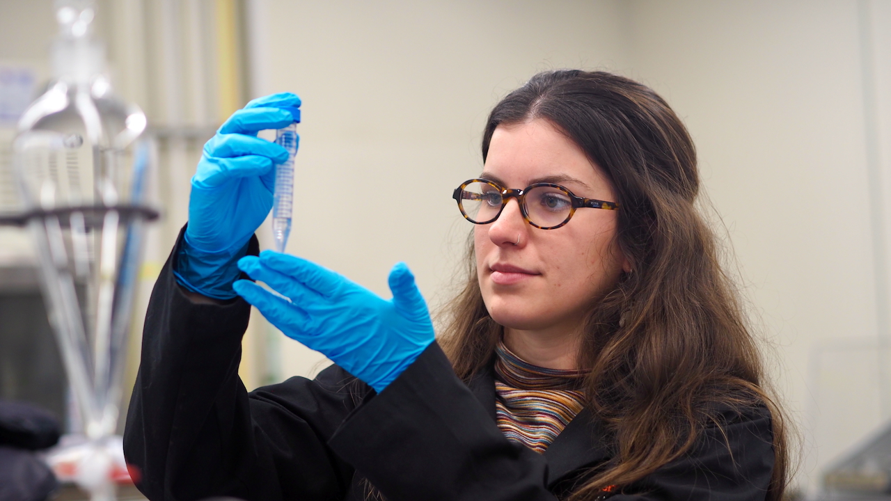 caption: Katie Moloney, a PhD student at the University of British Columbia and lead author on a study documenting the impact of runoff from artificial fields on coho salmon, measures out a water sample. 