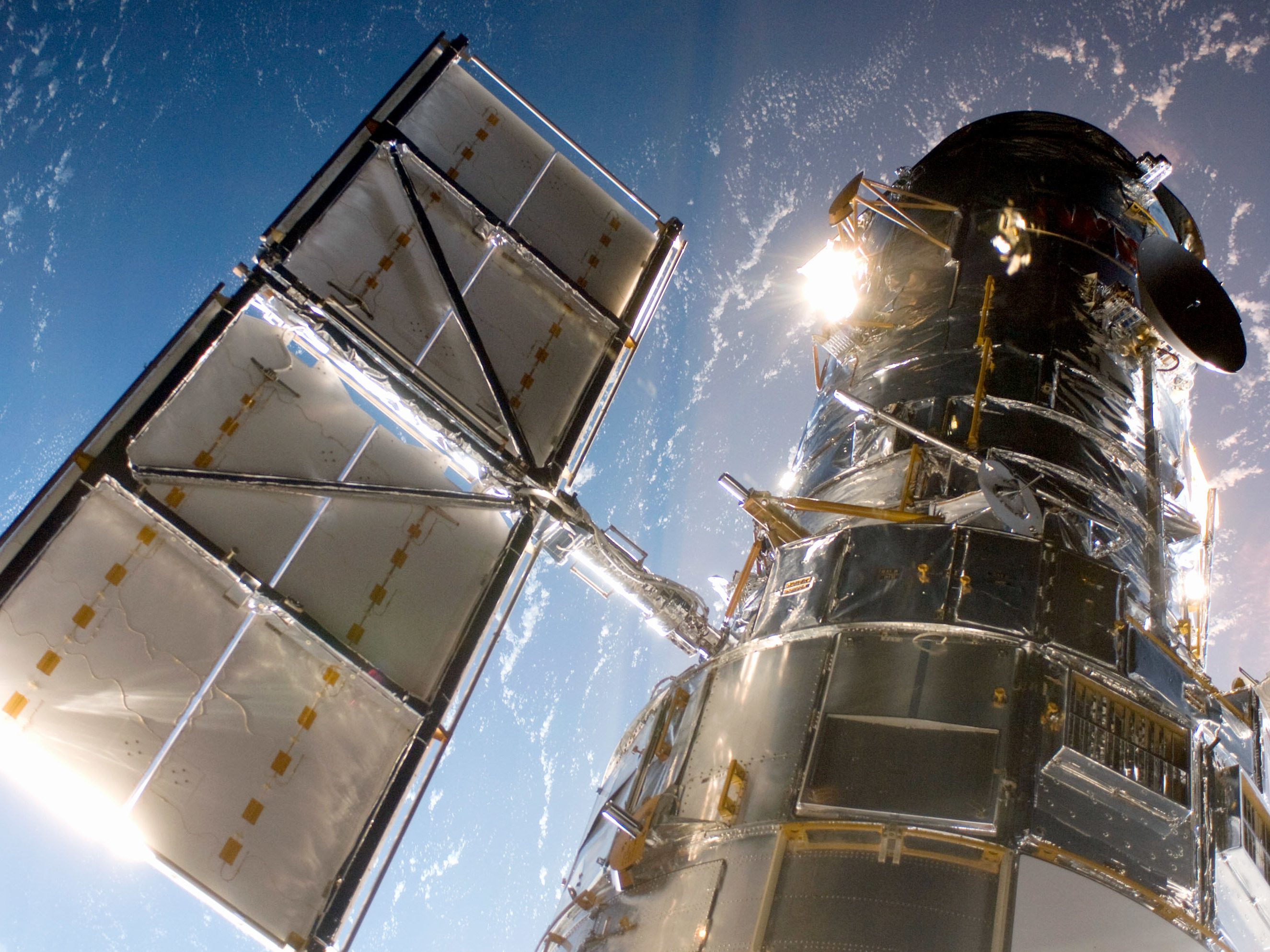 caption: In this handout from NASA, the Hubble Space Telescope is grappled to Space Shuttle Atlantis STS-125 by the shuttle's Canadian-built remote manipulator system May 13, 2009 in Space.