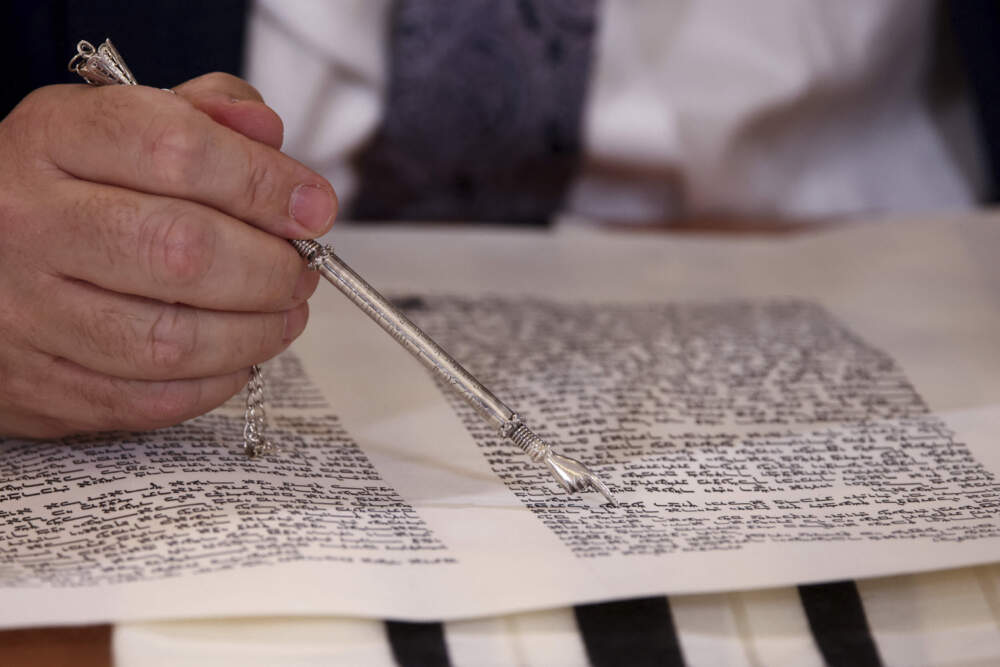 caption: Rabbi Avichai Apel holds a yad Torah pointer. (Liesa Johannssen/Pool Photo via AP)