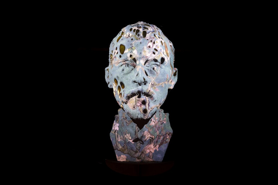 caption: Projections are cast on a large-scale 9-foot bust of Vincent Van Gogh at the immersive exhibit on Tuesday, October 26, 2021, along Occidental Avenue in Seattle.