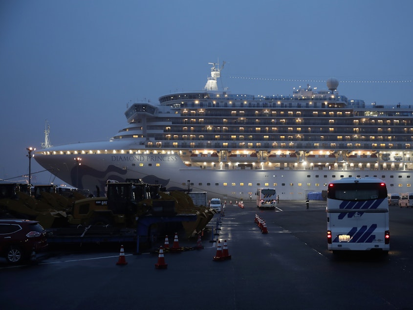 caption: Buses arrive at Yokohama Port, near Tokyo, as the Japan Self-Defense Forces prepare to move American passengers from the quarantined Diamond Princess cruise ship on Sunday.