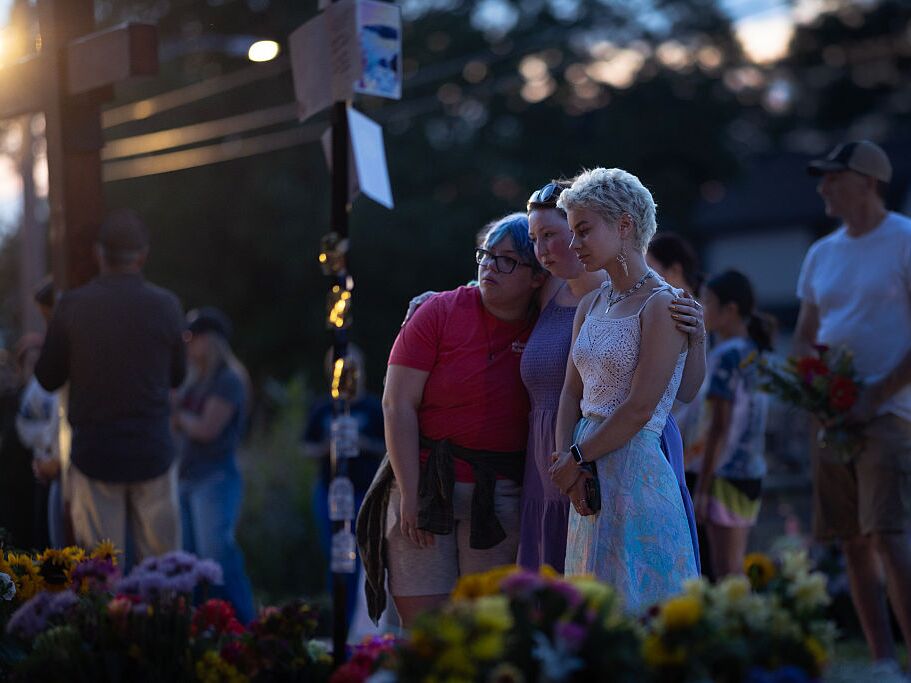caption: People gather at a memorial for victims of Wednesday's shooting at Annunciation Catholic Church in south Minneapolis. Two children were killed and 18 other people were injured.
