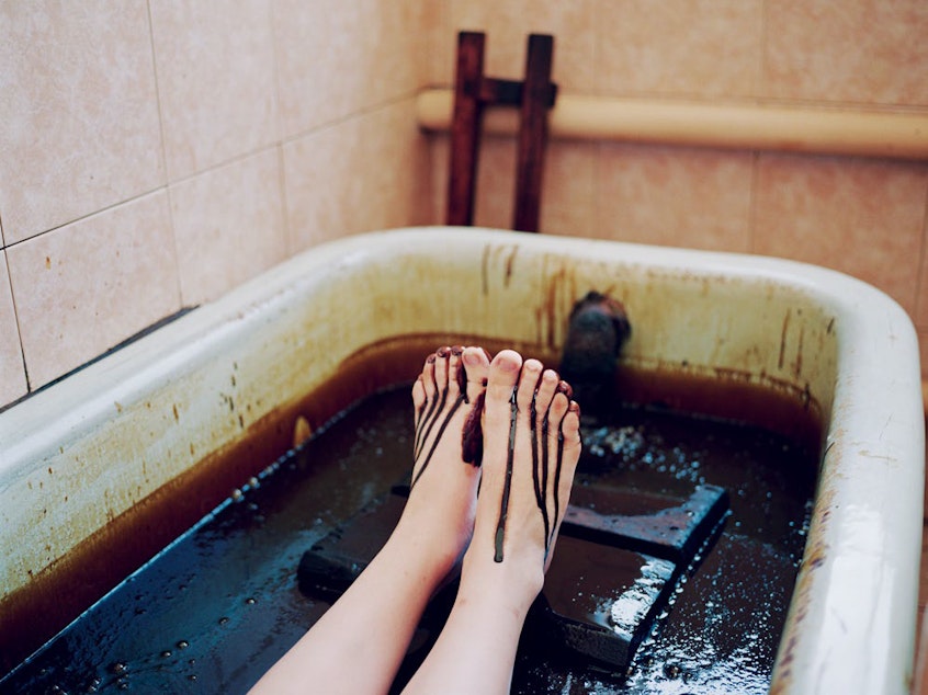 caption: A young woman bathes in crude oil at the sanatorium town of Naftalan. This "miracle oil" is found exclusively in the semidesert region of central Azerbaijan. It's claimed that bathing in it for 10 minutes a day has medicinal benefits. Naftalan, Azerbaijan, 2010.