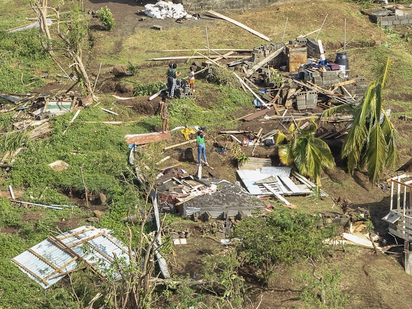 caption: Family members survey their home destroyed by Hurricane Beryl, in Ottley Hall, St. Vincent and the Grenadines, on Tuesday. Beryl is the most powerful storm to form this early in the Atlantic hurricane season.