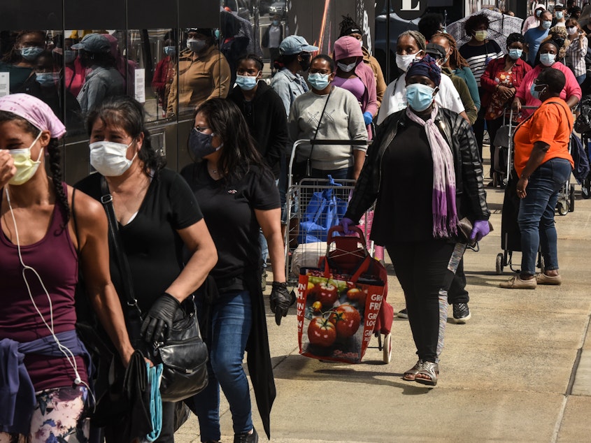 caption: People wait in a long line to receive a food bank donation at the Barclays Center on May 15 in Brooklyn, N.Y. Across the country, cities and towns are dealing with the highest unemployment rates since the Great Depression.