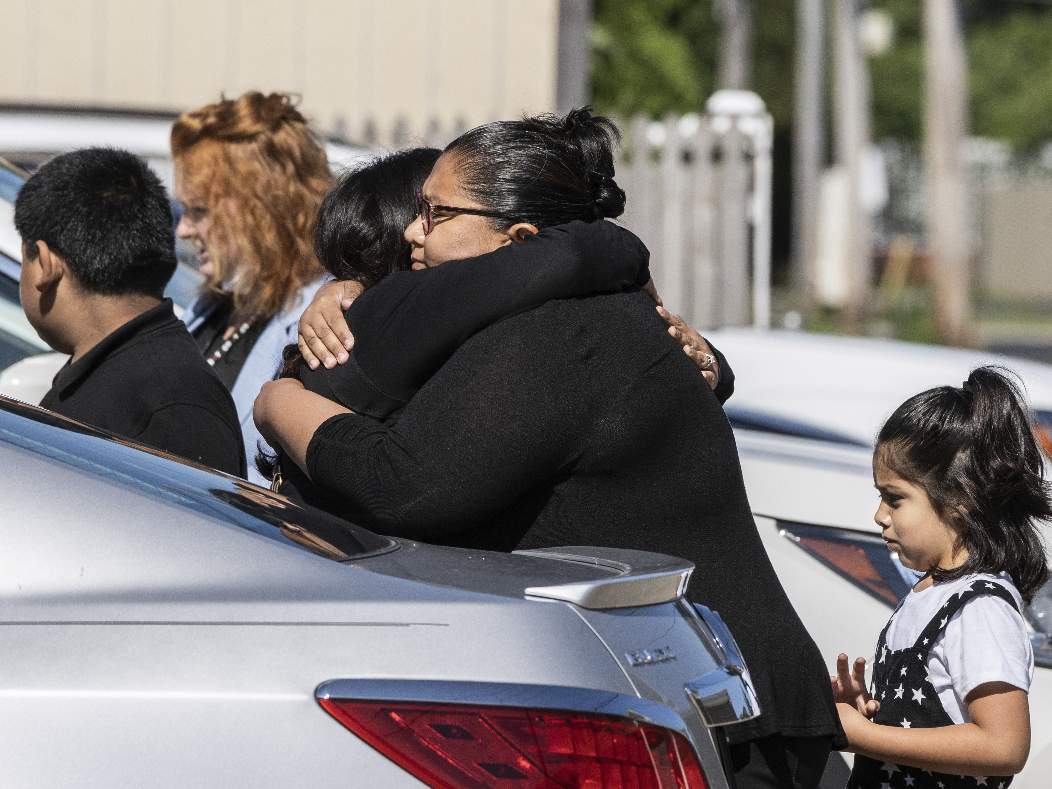 caption: Mourners hug Saturday outside Memorial Chapel Funeral Home in Waukegan, Ill., during funeral services for Eduardo Uvaldo, who was killed Monday during a mass shooting at the Fourth of July parade in Highland Park.