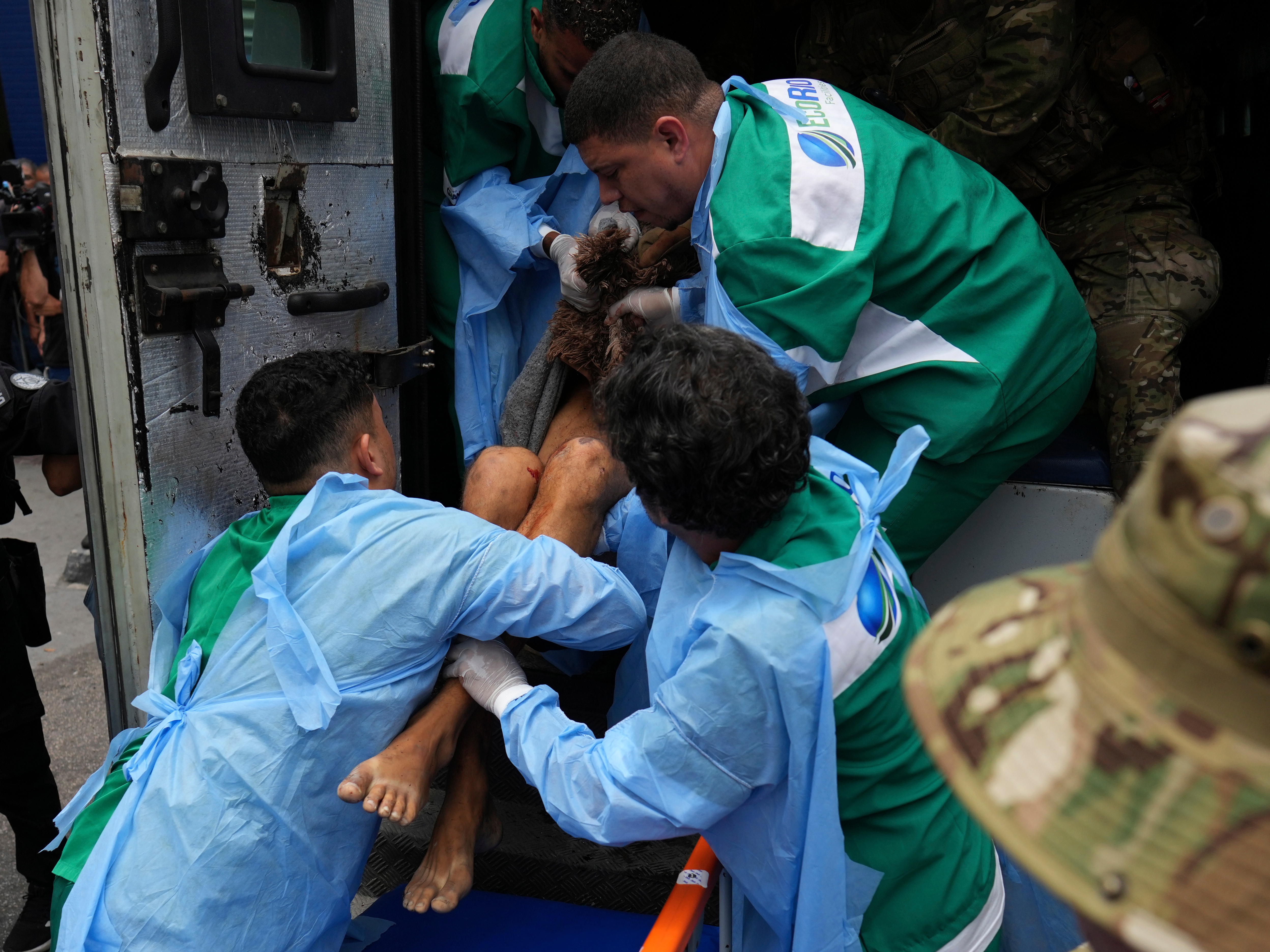 caption: Getulio Vargas Hospital workers remove an injured person from a police truck after he was injured in a police operation against alleged drug traffickers in the Complexo do Alemao favela where the criminal organization "Comando Vermelho" operates in Rio de Janeiro, on Tuesday.