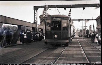 caption: A streetcar makes its way across Seattle's University Bridge in 1919. Behind the controls during this celebratory first crossing is the mayor, Ole Hanson.