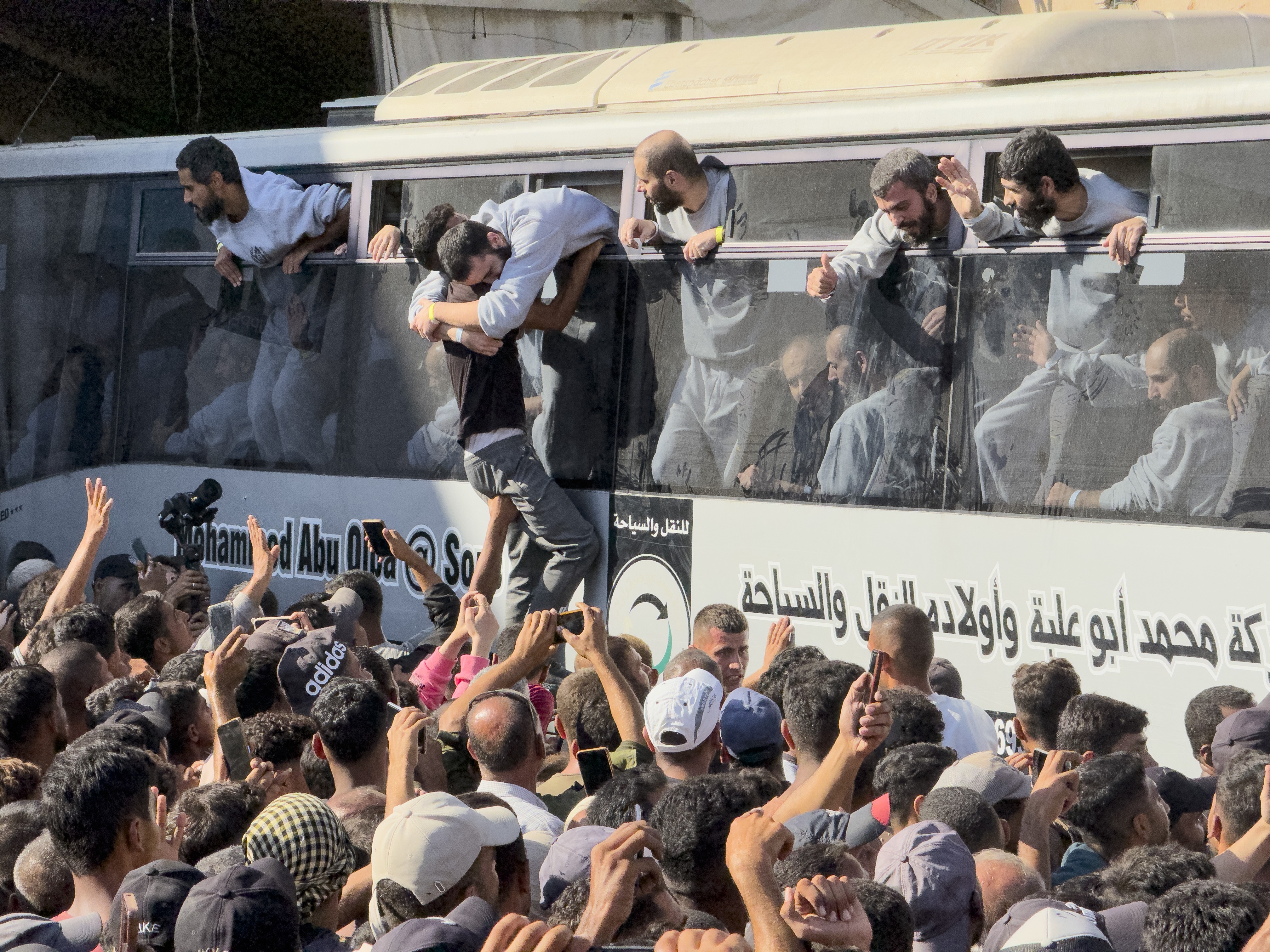caption: A bus carrying Palestinians released from Israeli prisons is greeted by a crowd outside the Nasser hospital in Khan Younis, Gaza Strip, on Monday.
