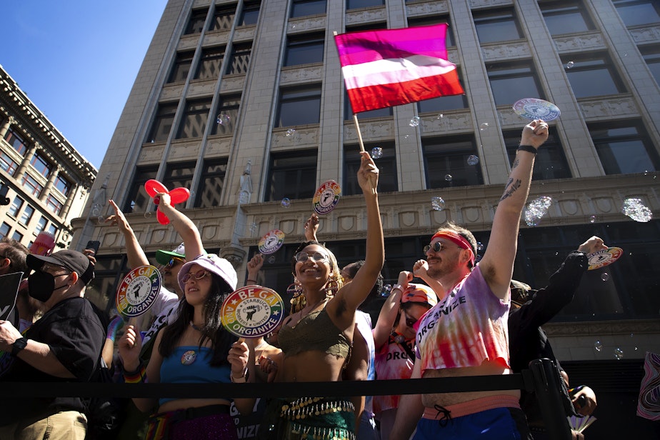caption: Members of the Starbucks union cheer and wave toward the crowds during Seattle’s Pride Parade on Sunday, June 25, 2023, in downtown Seattle.  