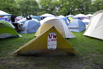 caption: ‘UW must divest from Israel’s apartheid state. Fuck Boeing, students stand with Palestine,’ reads a handmade sign within the ‘Popular University for Gaza liberated zone,’ on Tuesday, May 7, 2024, at the University of Washington campus Quad in Seattle. 