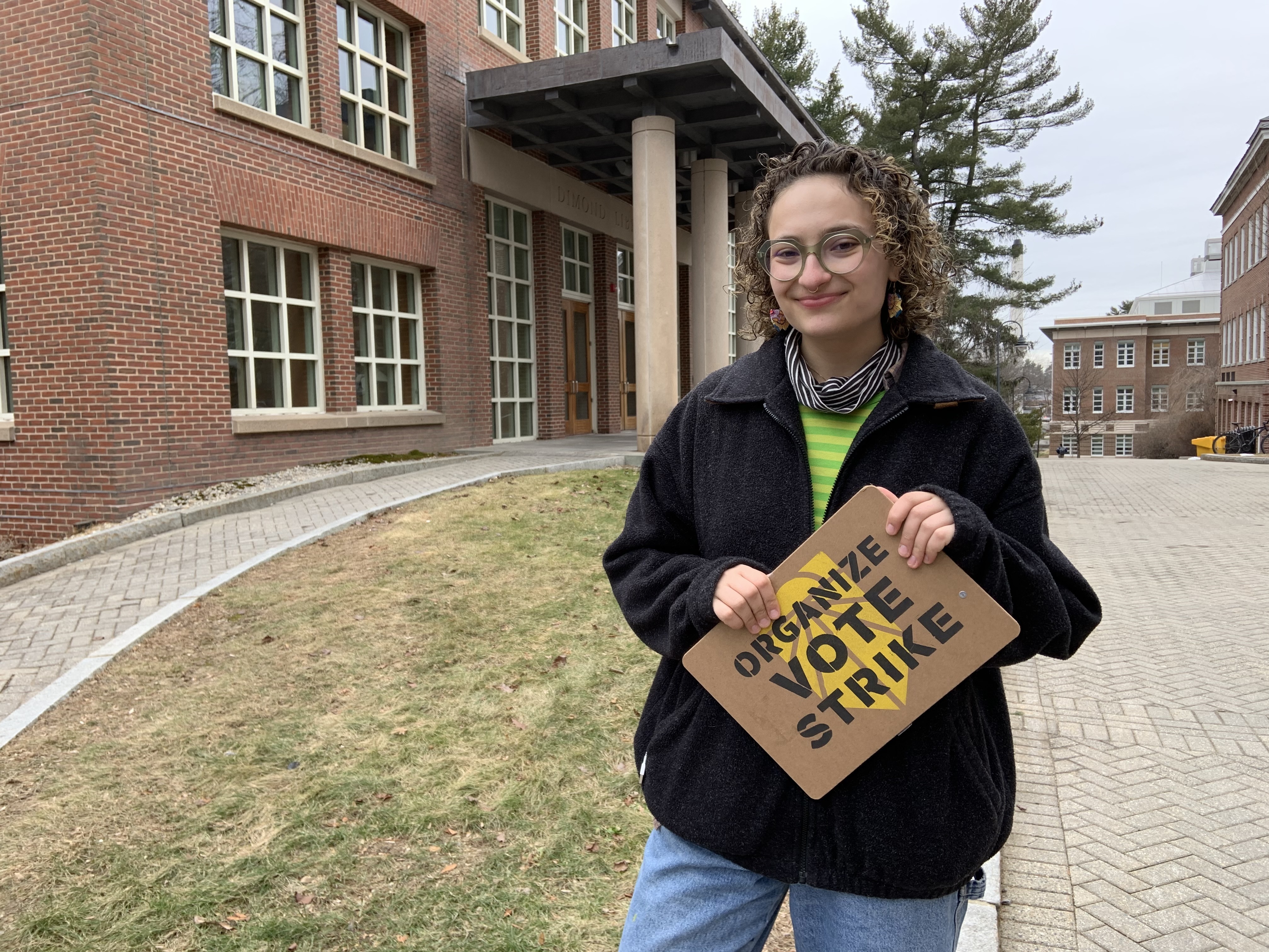 caption: Olivia Freiwald, 20, of the New Hampshire Youth Movement and Sunrise Movement on the main campus of the University of New Hampshire. She's campaigning for Bernie Sanders, in part, because he pledges to ban fracking.