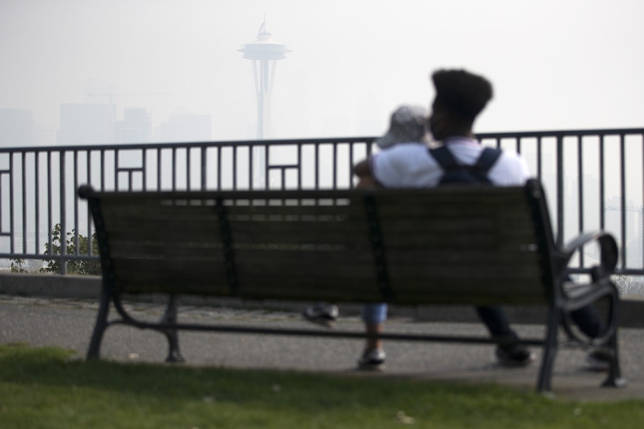 caption: Kathalina Hoffman, left, and Brian Muoneke, right, look toward downtown Seattle inside a massive plume of smoke from wildfires burning in California and Oregon on Sept. 11, 2020, at Kerry Park in Seattle.