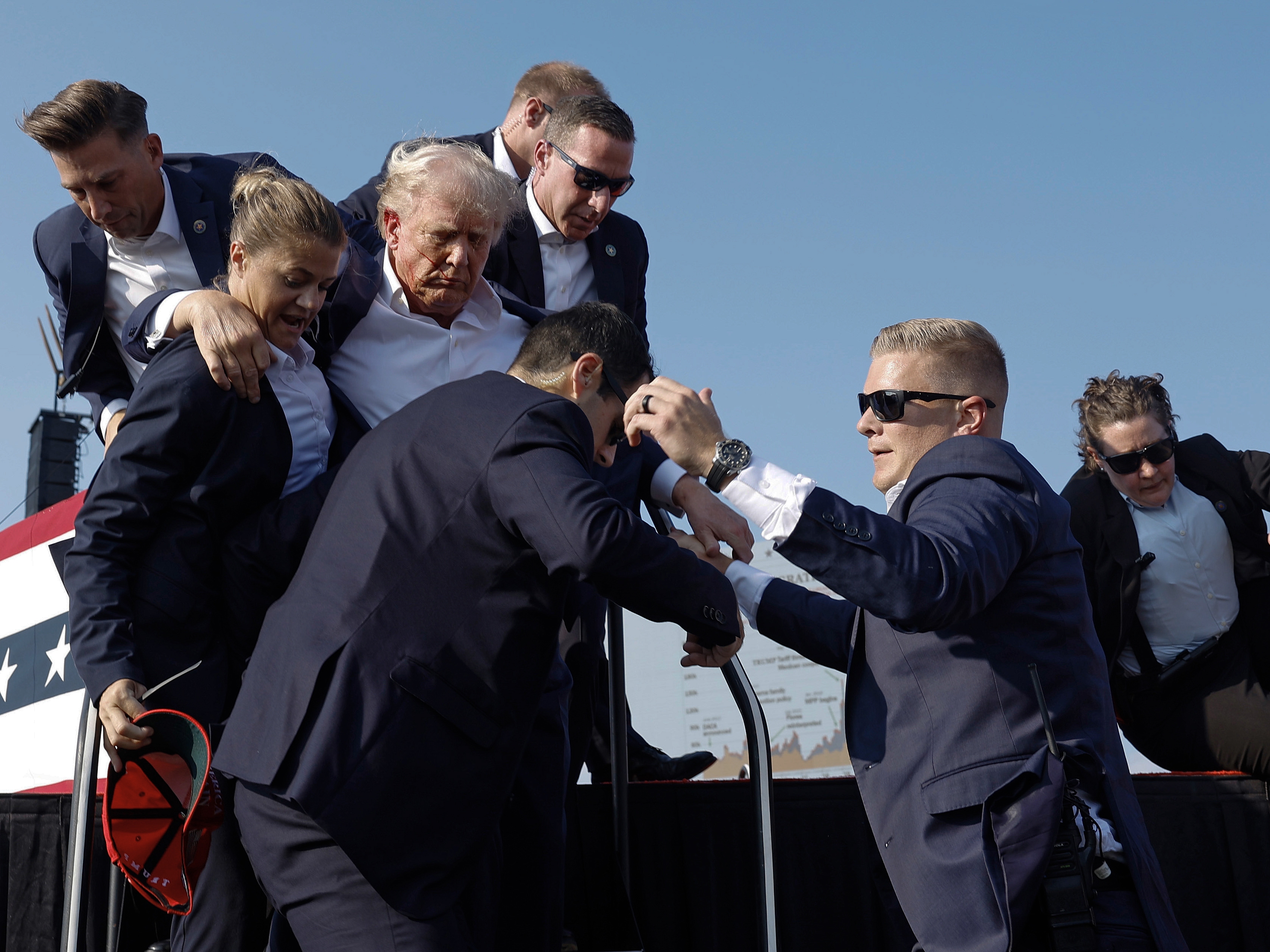 caption: Then-candidate Donald Trump is rushed offstage by U.S. Secret Service agents after being struck by a bullet during a rally on July 13, 2024, in Butler, Pa.