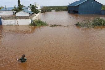 caption: A man swims from a submerged church compound, after the River Tana broke its banks following heavy rains at Mororo, border of Tana River and Garissa counties, northeastern Kenya, April 28. Heavy rains pounding different parts of Kenya have led to dozens of deaths and the displacement of tens of thousands of people, according to the United Nations.