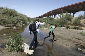 caption: Migrants cross the Rio Grande into the United States, to turn themselves over to authorities and ask for asylum, in Ciudad, Juarez, in June.