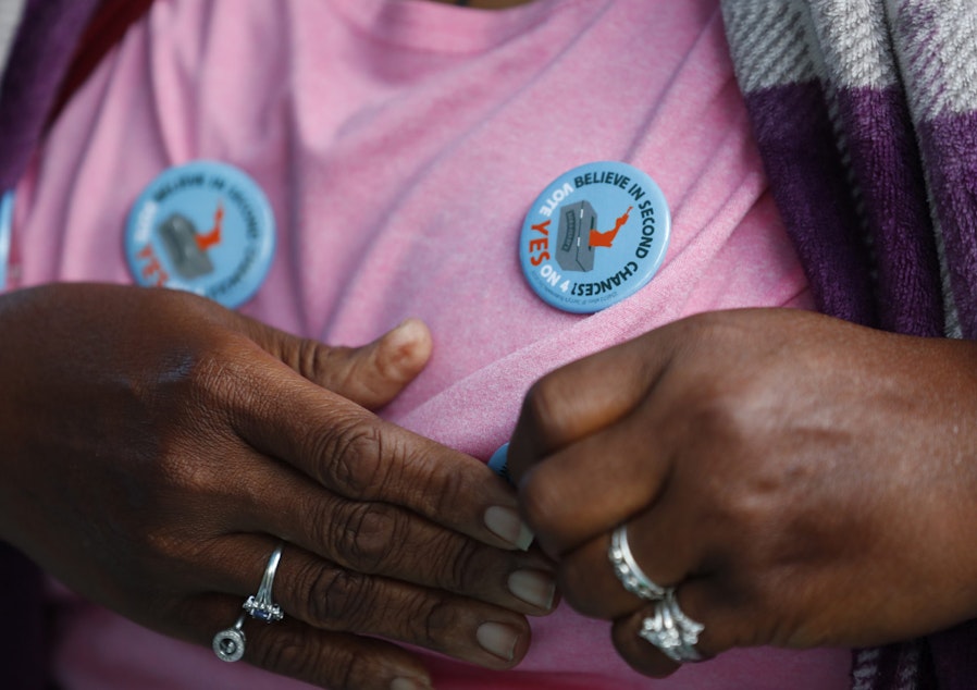 caption: Yvette Demerit puts on a button in support of Amendment 4 at the Ben & Jerry's "Yes on 4" truck at Charles Hadley Park in Miami on Oct. 22, 2018. The amendment asking voters to restore voting rights to people with past felony convictions passed on election night. (Wilfredo Lee/AP)