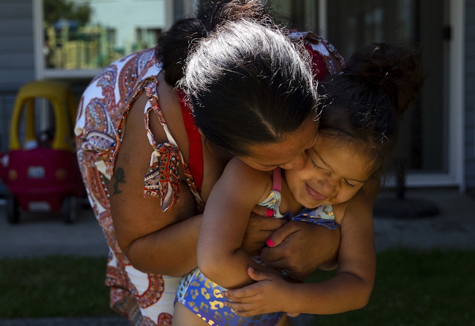 caption: Tynikki Arnold kisses her 5-year-old daughter Vay’s cheek while playing outside of their apartment on Friday, July 15, 2022. 