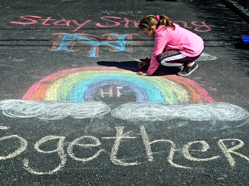 Girl makes chalk drawings on the driveway of their West Islip, New York.