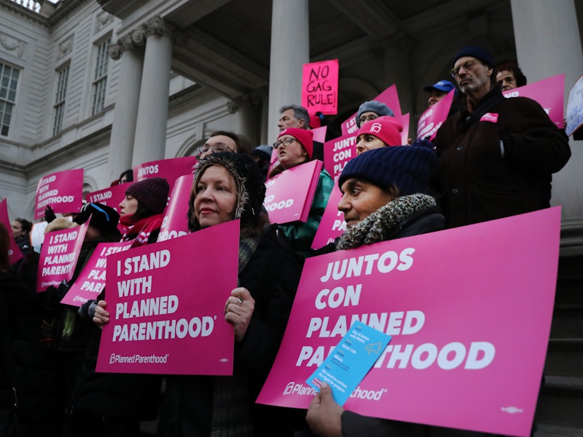 caption: Abortion-rights activists, politicians and others associated with Planned Parenthood gather for a demonstration against the Trump administration's Title X rule change on Feb. 25 in New York. Multiple lawsuits have been filed opposing the new rule.