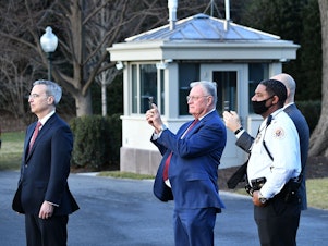 caption: White House Counsel Pat Cipollone, left, is seen with Keith Kellog, center, national security adviser to Vice President Mike Pence, watching Marine One carrying President Donald Trump leave the White House ahead of President-elect Joe Biden's inauguration on Jan. 20, 2021.