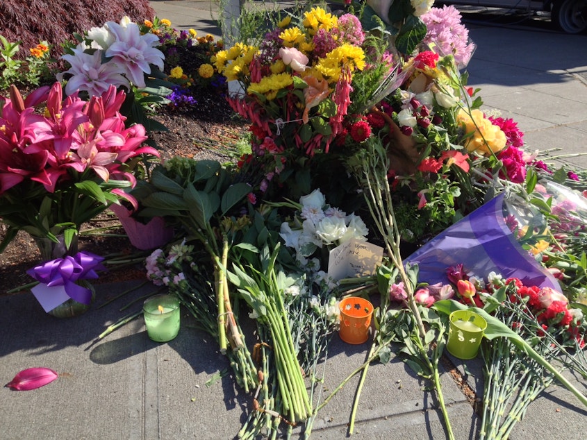 caption: Flowers are placed near a Seattle Pacific University sign on Third Avenue and Nickerson Street Friday morning.