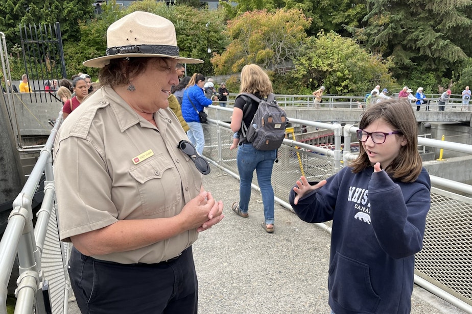 caption: Stacey Gilbert answers questions all day long about fish including one from Avery Clarke