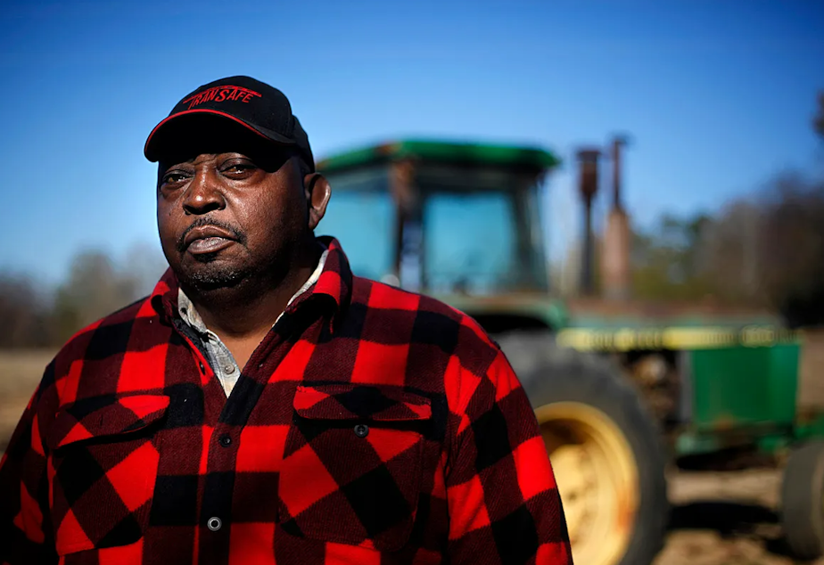 caption: Lucious Abrams, a plaintiff in the Pigford v. Glickman class action lawsuit, stands in front of a tractor on his Georgia farm.