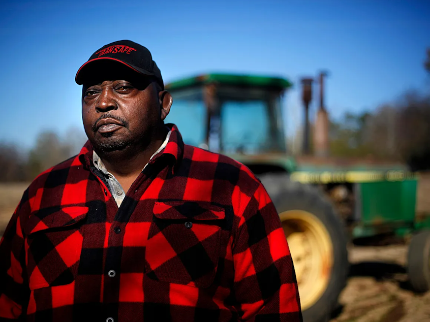 caption: Lucious Abrams, a plaintiff in the Pigford v. Glickman class action lawsuit, stands in front of a tractor on his Georgia farm.