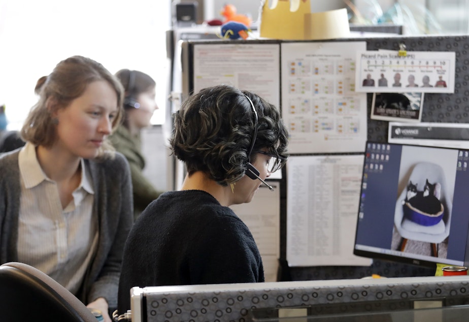 caption: Washington says it will launch contact tracing teams to map coronavirus exposure. Here, public health nurse Jennifer Morgan, right, checks-in via phone with a patient self-quarantined at home in February. University of Washington epidemiology student Erika Feutz observes in Seattle.