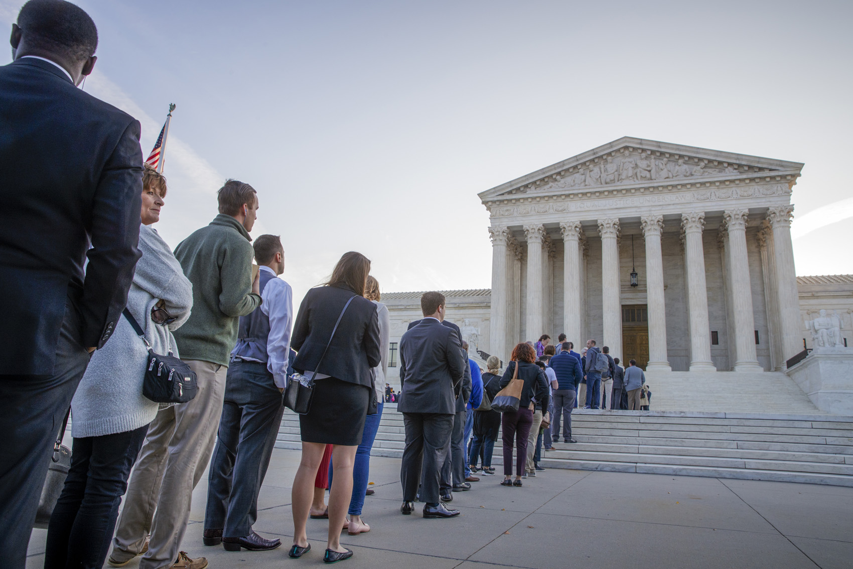 caption: People line up at the Supreme Court on the first day of the new term, on Capitol Hill in Washington, Monday, Oct. 1, 2018. Amid the political chaos of Judge Brett Kavanaugh's nomination, the high court's work begins with only eight justices on the bench, four conservatives and four liberals. (AP Photo/J. Scott Applewhite)