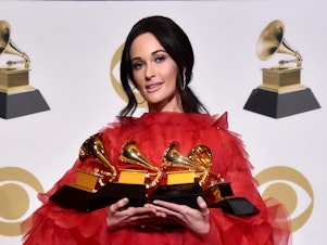caption: Kacey Musgraves holds the four Grammys she won Sunday night.