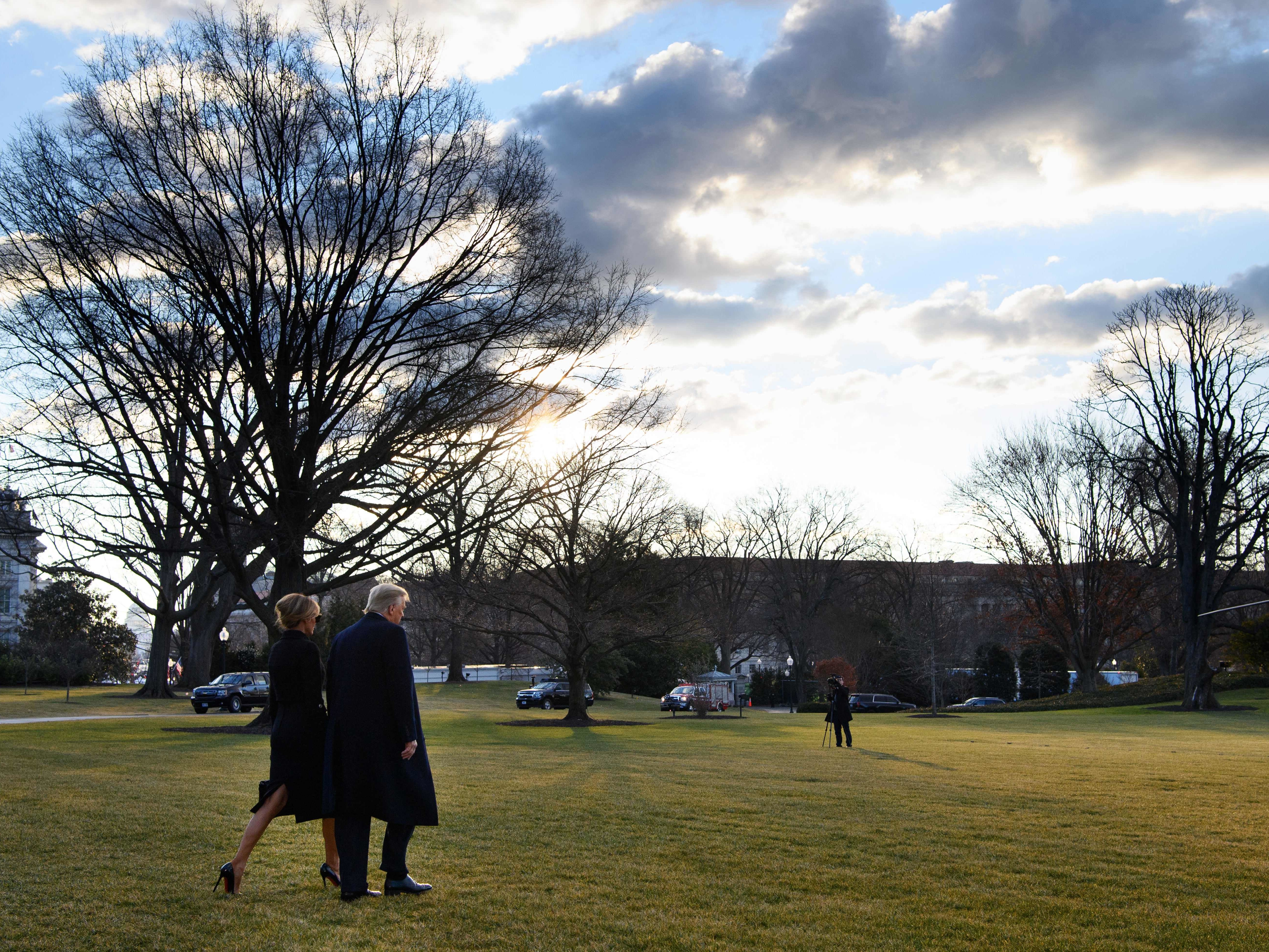 caption: President Trump and first lady Melania Trump make their way to board Marine One as they depart the White House for the last time.