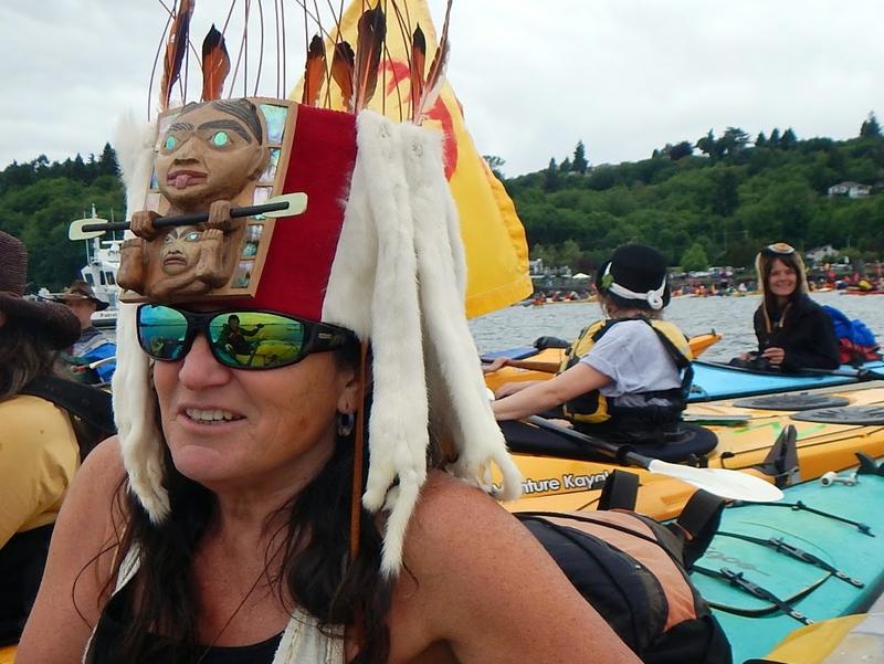 caption: Irene Skyriver, wearing a Tlingit headdress of an otter paddler, came from Lopez Island with her grandson for Saturday’s protest. She said she didn’t know whether a bunch of kayaking protesters could alter the actions of energy giant Shell Oil.