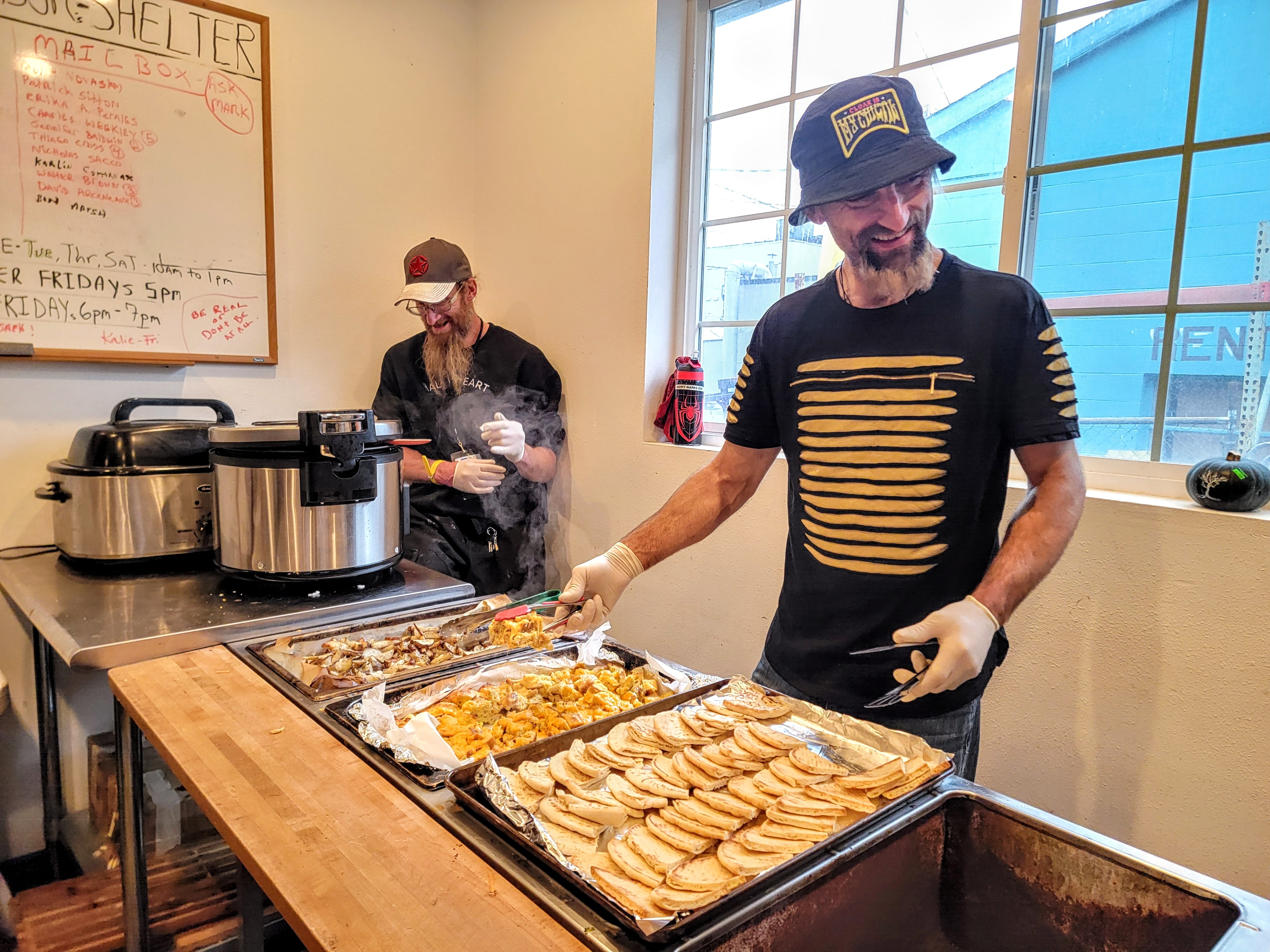 caption: David Birdwell (right) and Mark West serve breakfast at the shelter on Wednesday, Dec. 3, 2025.